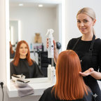 Woman with red hair getting a hair treatment from a stylist in a salon.