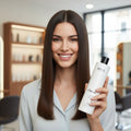 Woman holding a Nika Maximum smooth hair treatment in a salon setting