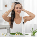 Woman washing nika hair healthy scalp with a bottle of shampoo and aloe vera leaves on a white background